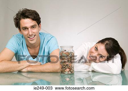 Couple with jar of coins View Large Photo Image Stock Image - Couple with jar of coins. Fotosearch