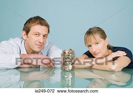 Couple with jar of coins View Large Photo Image Stock Image - Couple with jar of coins. Fotosearch
