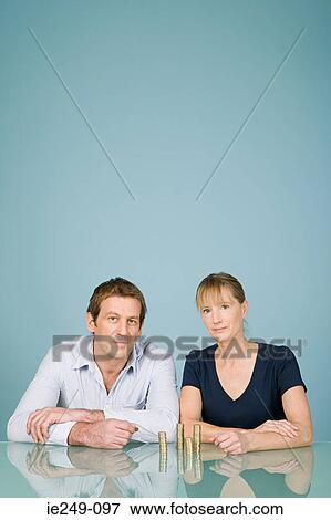 Couple with stacks of coins View Large Photo Image Stock Photo - Couple with stacks of coins. Fotosearch