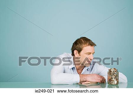 Man looking at jar of coins View Large Photo Image Stock Image - Man looking at jar of coins. Fotosearch