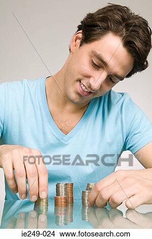Man stacking coins View Large Photo Image Picture - Man stacking coins. Fotosearch
