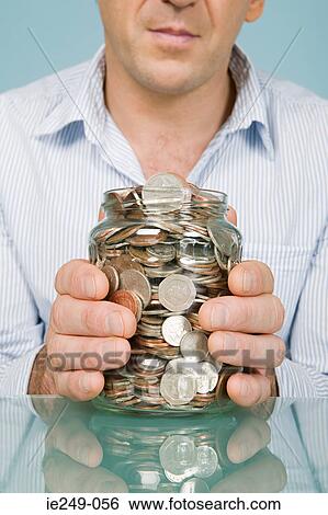 Stock Photograph - Man with jar of coins. Fotosearch