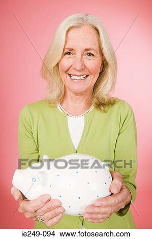 Woman holding a piggy bank View Large Photo Image Picture - Woman holding a piggy bank. Fotosearch