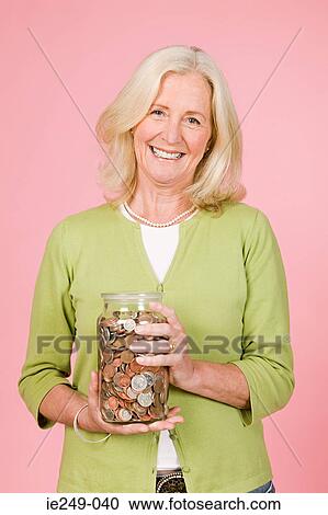 Woman holding jar of coins View Large Photo Image Stock Image - Woman holding jar of coins. Fotosearch