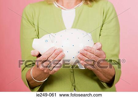 Woman holding piggy bank View Large Photo Image Stock Image - Woman holding piggy bank. Fotosearch