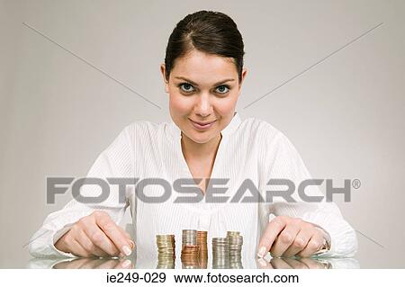 Woman with stacks of coins View Large Photo Image Stock Photo - Woman with stacks of coins. Fotosearch