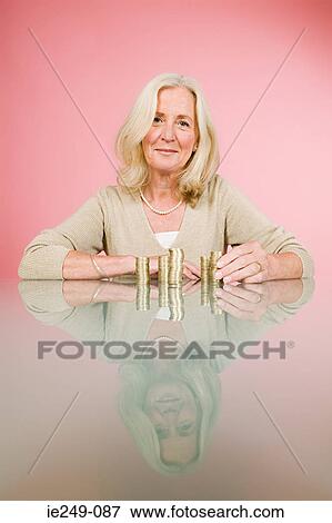 Stock Photo - Woman with stacks of coins. Fotosearch