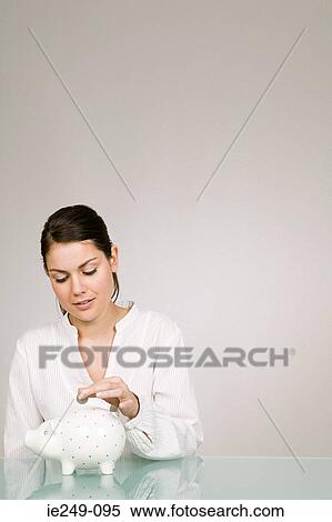 Stock Photography - Young woman with piggy bank. Fotosearch