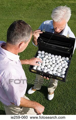 A businessman taking a golf ball from a briefcase View Large Photo Image Stock Image - A businessman taking a golf ball from a briefcase. Fotosearch