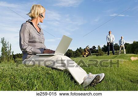 A businesswoman watching colleagues playing golf View Large Photo Image Stock Photography - A businesswoman watching colleagues playing golf. Fotosearch