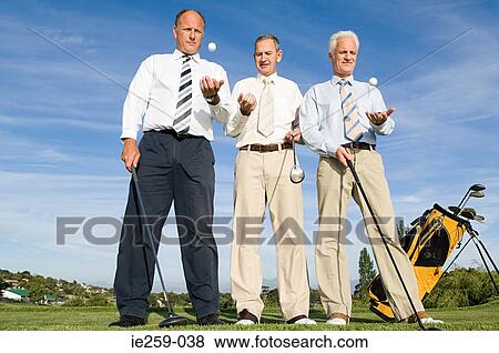 Stock Photo - businessmen throwing golf balls. Fotosearch