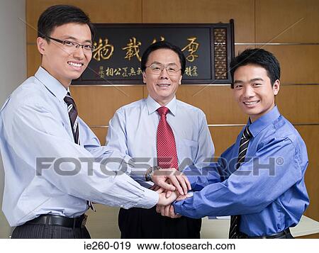 Stock Photo - Businessmen putting hands together. Fotosearch