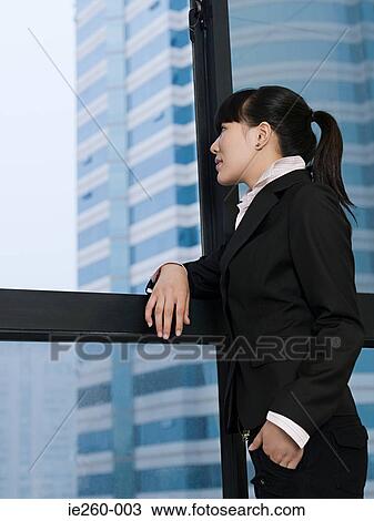 Businesswoman looking through window View Large Photo Image Stock Image - Businesswoman looking through window. Fotosearch