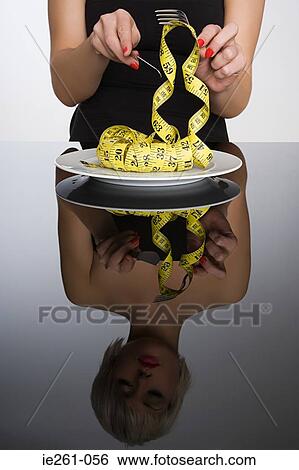 Woman eating a tape measure View Large Photo Image Stock Photograph - Woman eating a tape measure. Fotosearch