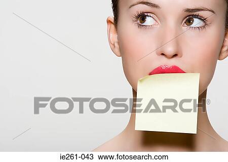 Stock Image - Woman with adhesive note on her mouth. Fotosearch
