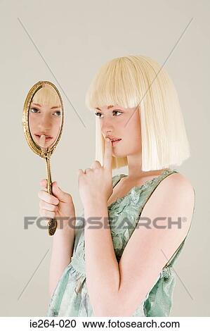 Young woman looking in mirror View Large Photo Image Stock Image - Young woman looking in mirror. Fotosearch