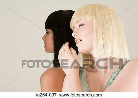 Young women whispering View Large Photo Image Stock Photo - Young women whispering. Fotosearch