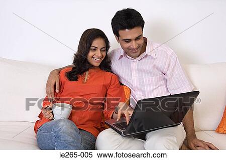A couple using a laptop View Large Photo Image Stock Photography - A couple using a laptop. Fotosearch