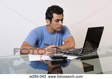 Stock Image - A man sorting his finances on a laptop. Fotosearch