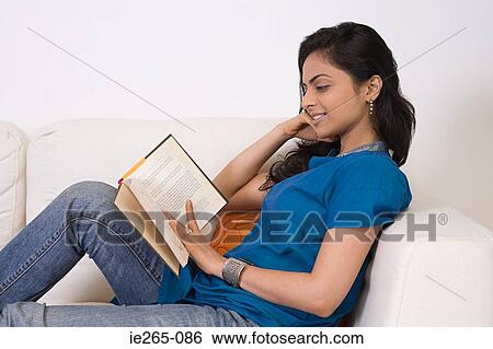 A young woman reading a book View Large Photo Image Stock Photograph - A young woman reading a book. Fotosearch