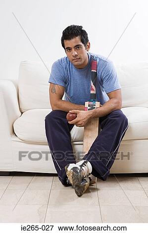 Portrait of a man holding a cricket bat View Large Photo Image Stock Photo - Portrait of a man holding a cricket bat. Fotosearch