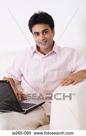 Portrait of a man using a laptop View Large Photo Image Stock Photography - Portrait of a man using a laptop. Fotosearch