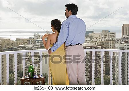 Rear view of a couple on a balcony View Large Photo Image Stock Image - Rear view of a couple on a balcony. Fotosearch