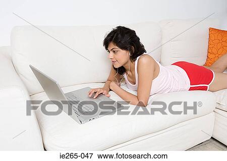 Young woman applying lipstick View Large Photo Image Stock Photo - Young woman applying lipstick. Fotosearch