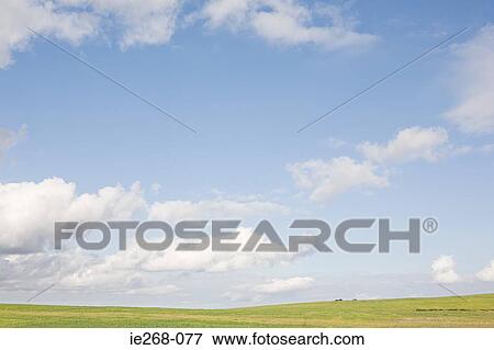 Stock Photo - Cloudy sky over a field. Fotosearch