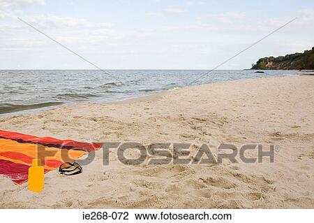 Stock Image - Towel on an empty beach. Fotosearch