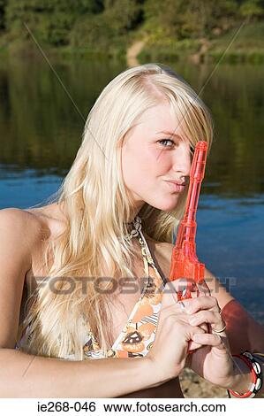 Woman posing with a toy gun View Large Photo Image Stock Photograph - Woman posing with a toy gun. Fotosearch