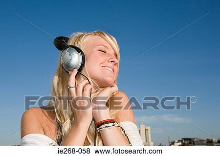 Young woman listening to music View Large Photo Image Stock Photo - Young woman listening to music. Fotosearch