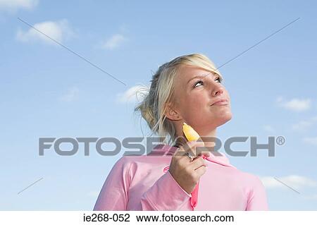 Young woman with an ice lolly View Large Photo Image Stock Image - Young woman with an ice lolly. Fotosearch
