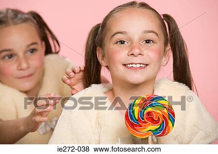 Twin girls with lollipop View Large Photo Image Stock Photo - Twin girls with lollipop. Fotosearch