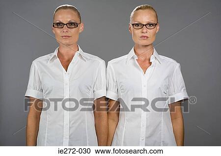 Stock Image - Twin sisters wearing glasses. Fotosearch
