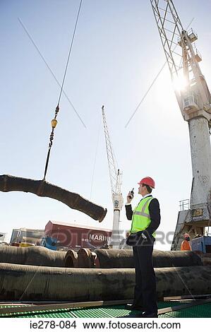 Engineer and crane lifting pipes View Large Photo Image Picture - Engineer and crane lifting pipes. Fotosearch