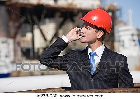 Stock Image - Engineer on cellphone. Fotosearch