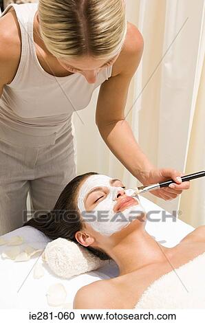 A beautician applying a face mask to a womans face View Large Photo Image Stock Image - A beautician applying a face mask to a womans face. Fotosearch