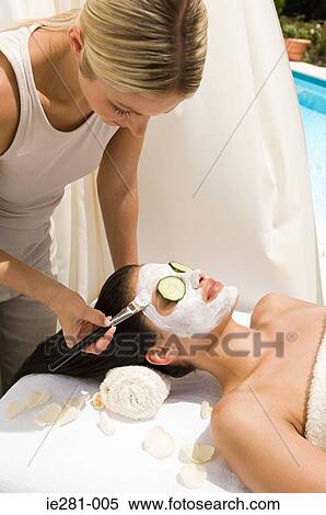 A beautician applying a face mask to a womans face View Large Photo Image Stock Photography - A beautician applying a face mask to a womans face. Fotosearch