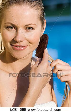 A woman combing her hair View Large Photo Image Stock Photograph - A woman combing her hair. Fotosearch