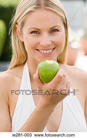 A woman holding an apple View Large Photo Image Stock Image - A woman holding an apple. Fotosearch