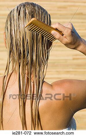 Rear view of a woman combing her hair View Large Photo Image Stock Image - Rear view of a woman combing her hair. Fotosearch