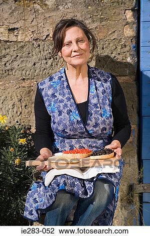 Mature woman holding slices of bruschetta View Large Photo Image Stock Image - Mature woman holding slices of bruschetta. Fotosearch