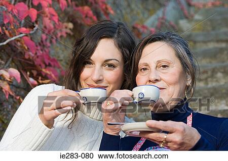 Mother and daughter drinking from small cups View Large Photo Image Stock Image - Mother and daughter drinking from small cups. Fotosearch