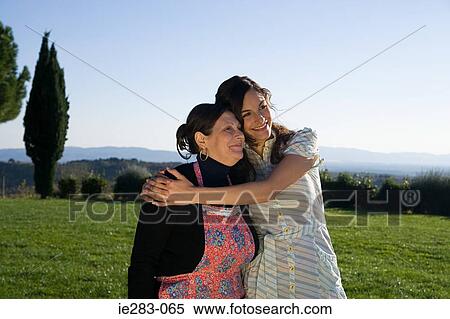 Mother and daughter hugging in a field View Large Photo Image Stock Photography - Mother and daughter hugging in a field. Fotosearch
