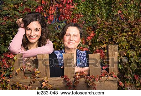 Mother and daughter leaning on a fence View Large Photo Image Stock Photo - Mother and daughter leaning on a fence. Fotosearch