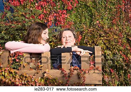 Mother and daughter leaning on a gate View Large Photo Image Stock Photo - Mother and daughter leaning on a gate. Fotosearch