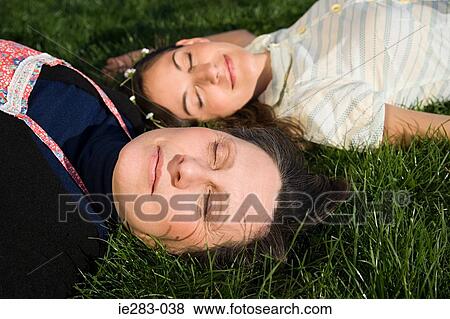 Mother and daughter sleeping on the grass View Large Photo Image Stock Photo - Mother and daughter sleeping on the grass. Fotosearch