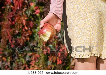 Woman holding a bitten apple View Large Photo Image Stock Photography - Woman holding a bitten apple. Fotosearch