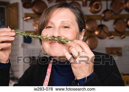 Woman smelling a sprig of rosemary View Large Photo Image Stock Photo - Woman smelling a sprig of rosemary. Fotosearch